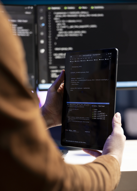 Personne tenant une tablette avec code informatique.